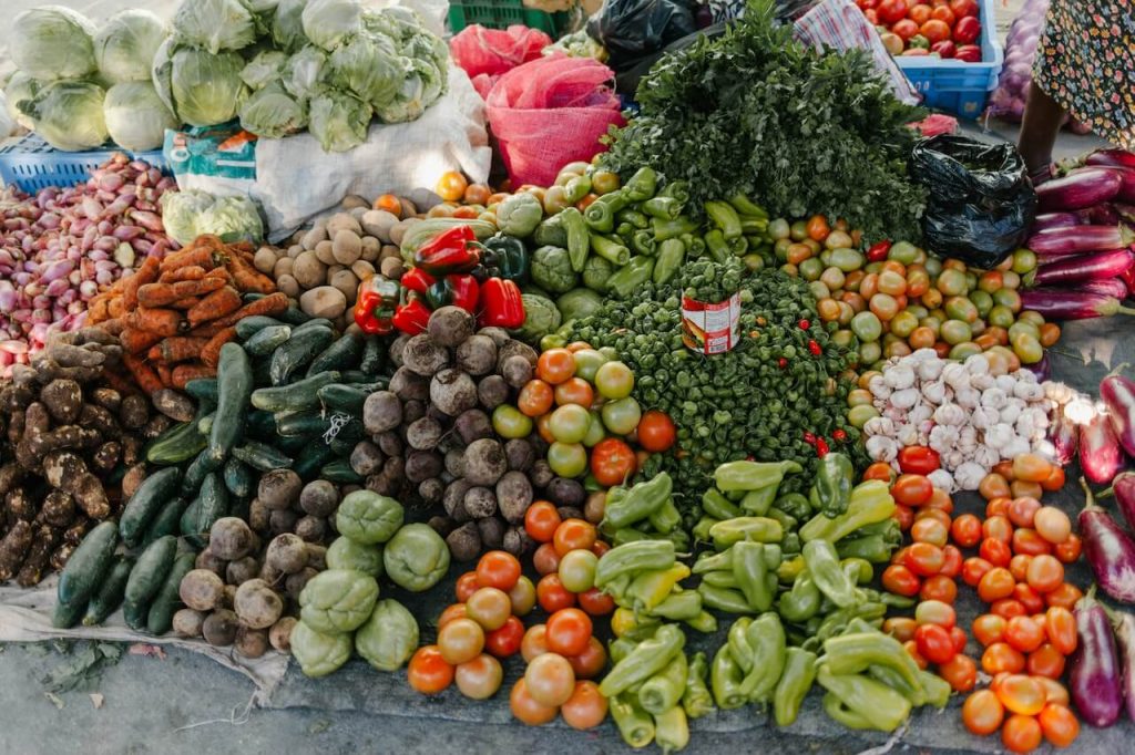 Eine lebendige Auslage mit verschiedenen Gemüsesorten an einem Stand, der eine Vielfalt an frischen Produkten präsentiert.